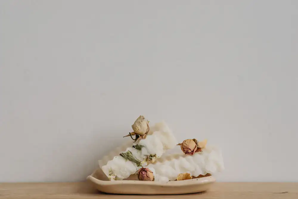 Close up of raw oats, botanical herbs, and natural soap blocks